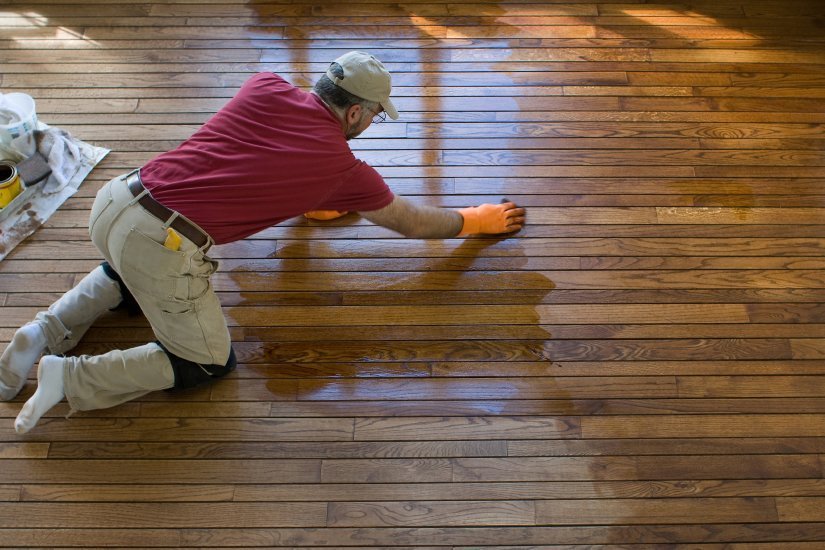 a technician refinishing a hardwood floor